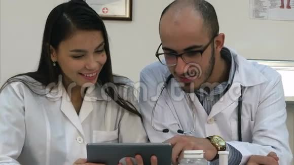 两个医生看着药片上有趣的东西笑了视频的预览图