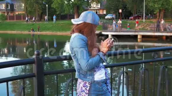 在城市公园使用智能手机的漂亮快乐女人stealam射击视频的预览图