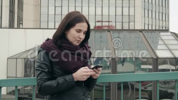 穿着休闲服的有吸引力的游客在智能手机上的应用用于在城市中航行臀部女孩站立视频的预览图