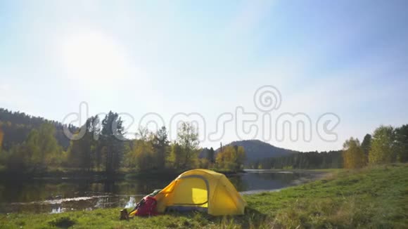 阿尔泰黄色帐篷在山湖畔花费红色背包和旅游靴两个视频合一视频的预览图