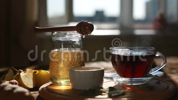 特写是真正的蜂蜜从勺子里慢慢排出早上好茶道一杯茶的特写视频的预览图