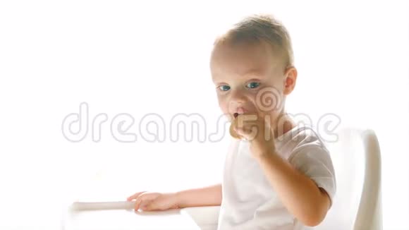 小男孩在白色背景下吃饼干视频的预览图