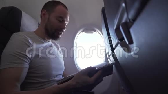 坐在飞机窗口附近的人看杂志的股票录像视频的预览图