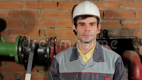 一个英俊的男性的肖像高加索黑发工程师戴着头盔的工人微笑视频的预览图