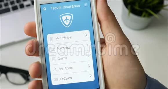 用坐在办公桌前的智能手机应用支付旅游保险视频的预览图