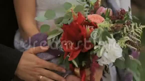 新娘夫妇拥抱温柔的抚摸给新婚夫妇戴上戒指和结婚花束视频的预览图