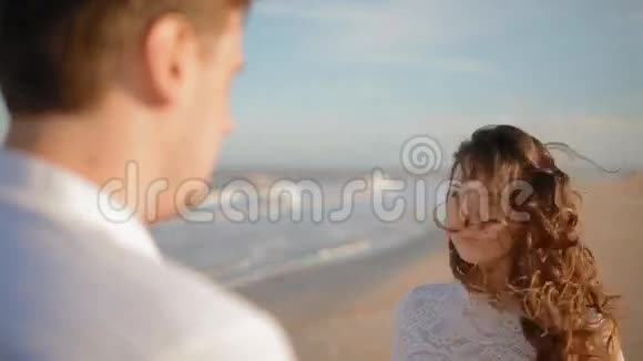 男人在海滩上亲吻女人的手视频的预览图
