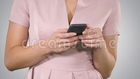 女人手在渐变背景下使用智能手机视频的预览图