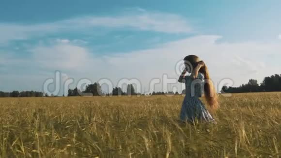 美丽浪漫女孩户外美丽的少女模特穿着休闲短装在阳光下的田野上吹弹视频的预览图