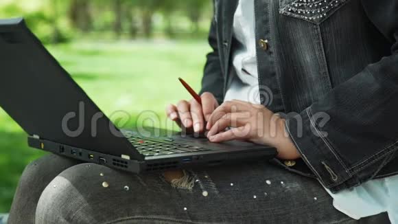 在城市公园里用笔记本电脑的女人视频的预览图