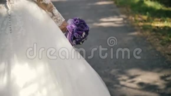从背面看新娘花束漫步在森林里视频的预览图