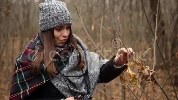 一个女孩带着相机拍摄一个寒冷的秋天视频的预览图