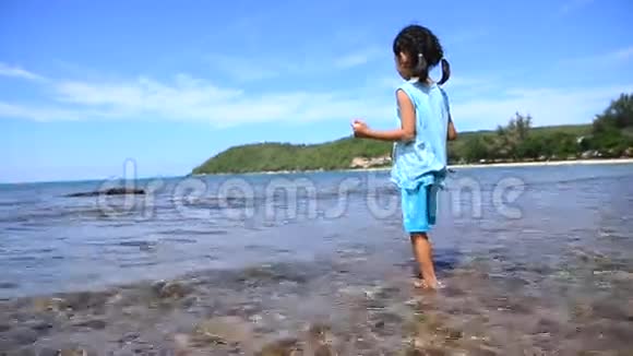 亚洲小女孩有着自然的海洋和蓝天波朝泰国SattahipChonburi海岸走去视频的预览图