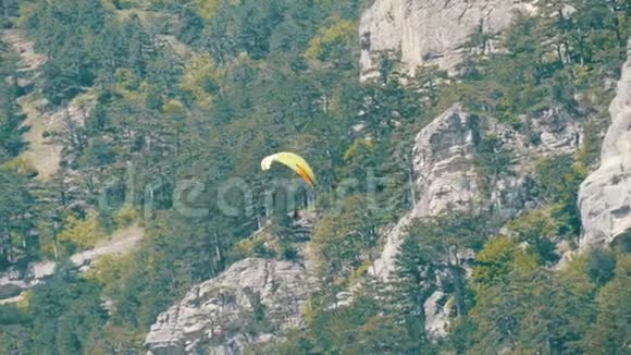 黄色滑翔伞在绿油油的克里米亚山脉背景下飞翔视频的预览图