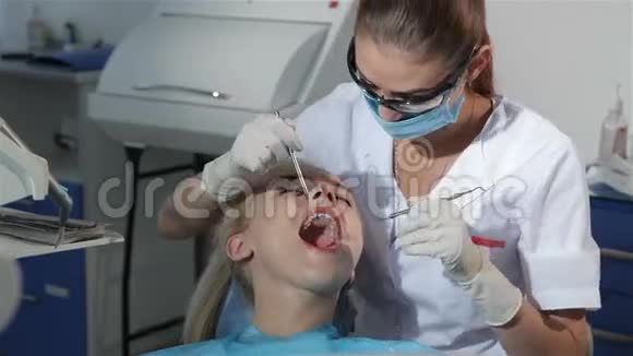 牙科医生用牙科探针检查病人的牙齿视频的预览图