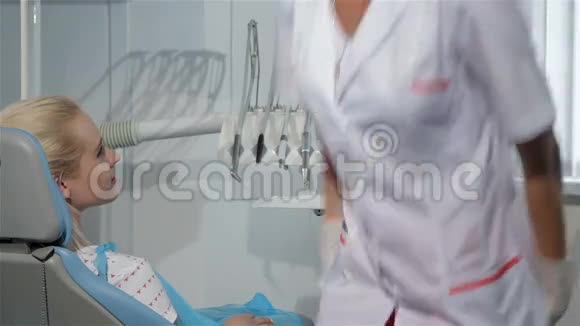 女牙医在牙医柜里看病人的嘴视频的预览图