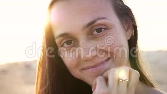 年轻女子情绪激动的脸在沙滩上特写肖像4k慢镜头视频的预览图