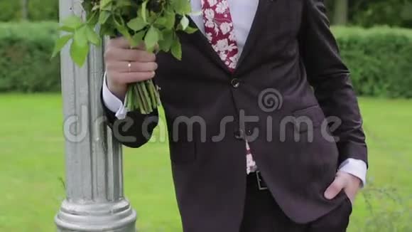 一个紧张的新郎带着一束花等待他的新娘慢动作视频的预览图