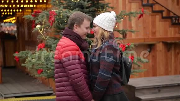 快乐的年轻夫妇在圣诞市场上尽情欢乐和亲吻男人和女人在一起度过时光视频的预览图