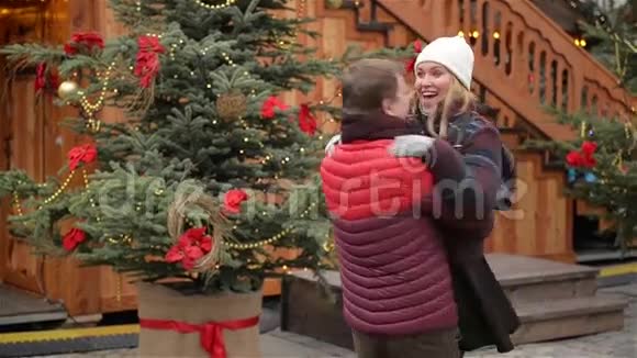 浪漫的约会情侣在圣诞集市上男人在旋转他的女朋友圣诞树在视频的预览图