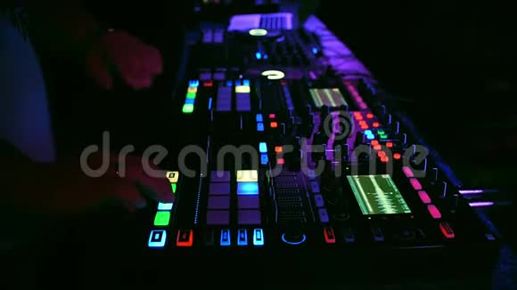 手持DJ在专业的音乐板混音器上播放和混合音乐视频的预览图