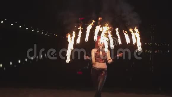黄昏时分女人在火炉边旋转燃烧的扇子视频的预览图