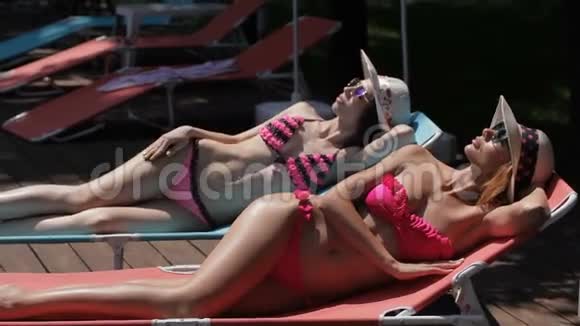 两个女人在游泳池附近晒日光浴视频的预览图