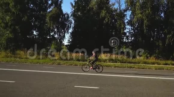 女人独自骑自行车在农村骑自行车度过她活跃的夏季周末视频的预览图