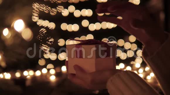 女人打开礼物盒在bokeh灯光背景上用金色的魔法视频的预览图