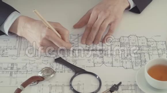 建筑师用铅笔和尺子在工作场所绘制建筑工程草图视频的预览图