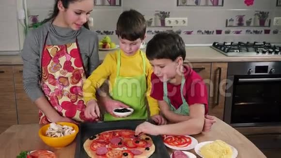 三个孩子在生披萨里加入橄榄视频的预览图