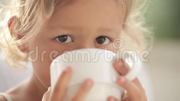 一幅美丽的小女孩的特写肖像配上一杯茶视频的预览图