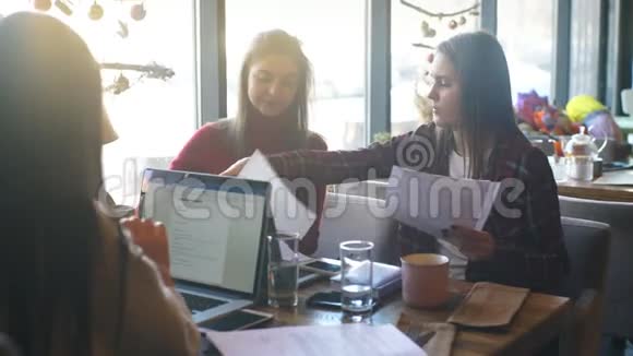 漂亮的女商人在咖啡馆里讨论文件喝杯咖啡视频的预览图