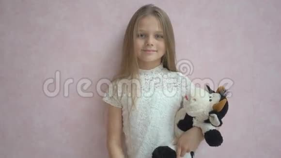 可爱的小女孩穿着休闲装手里拿着柔软的玩具对着相机微笑视频的预览图