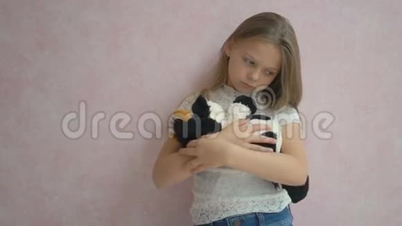 伤心的小女孩拿着玩具站在墙边视频的预览图