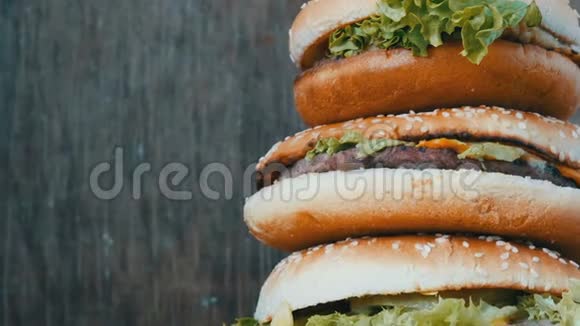 大山从三个美味多汁的汉堡与生菜和奶酪近景汉堡包一只躺在视频的预览图