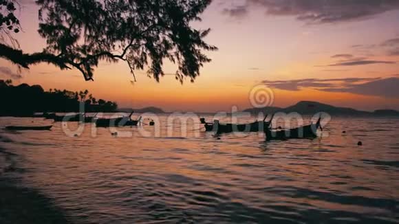 日出泰国普吉拉瓦海滩长尾渔船视频的预览图