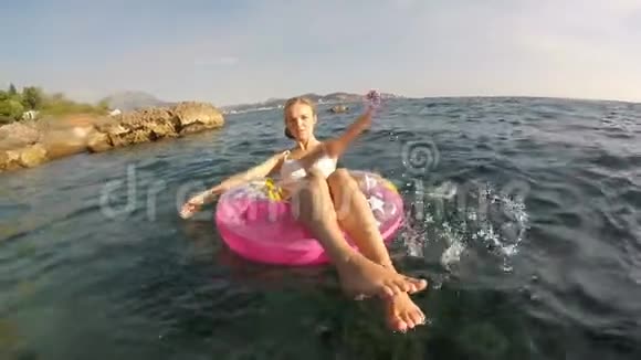 一个女人用粉红色的圆圈在海里洗澡视频的预览图