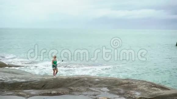 在海边拍照的年轻女子视频的预览图