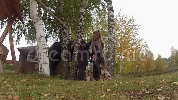 秋天和一匹黑马在秋千上的女孩视频的预览图