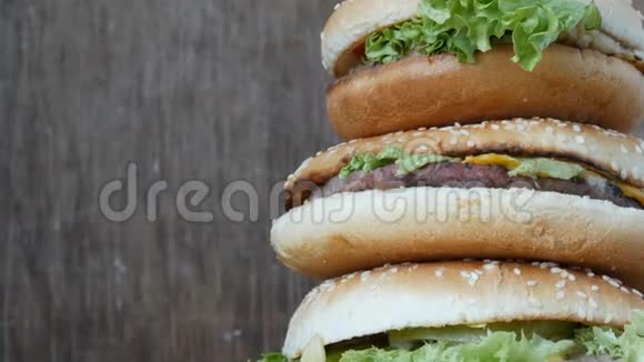 大山从三个美味多汁的汉堡和生菜和奶酪近距离观看汉堡包一只躺在视频的预览图