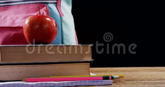 苹果和书包在书堆上视频的预览图