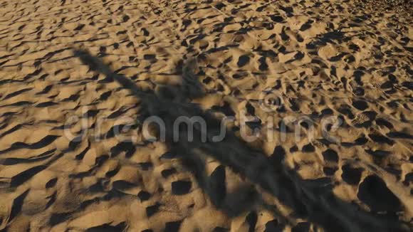 沙滩上的影子从跳舞的年轻人身上落下4K慢动作视频的预览图
