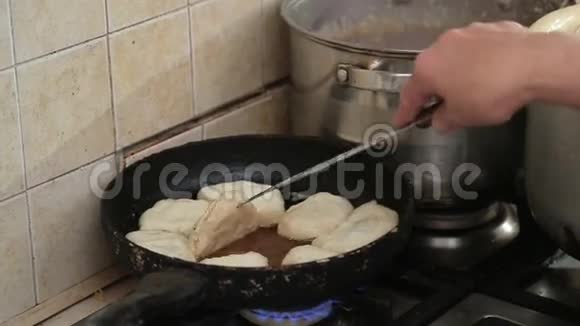 女人站在厨房的炉子旁做饭视频的预览图