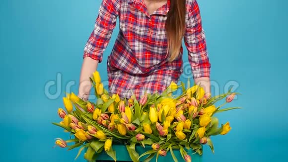 年轻的女花商带着一大盒黄色郁金香视频的预览图