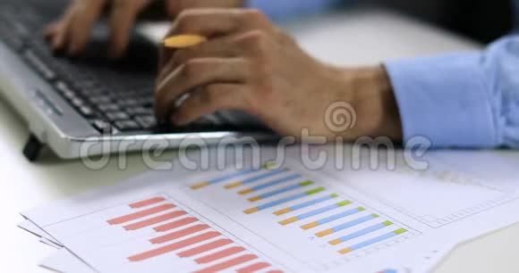 数据输入职员使用统计图表和键盘打字视频的预览图