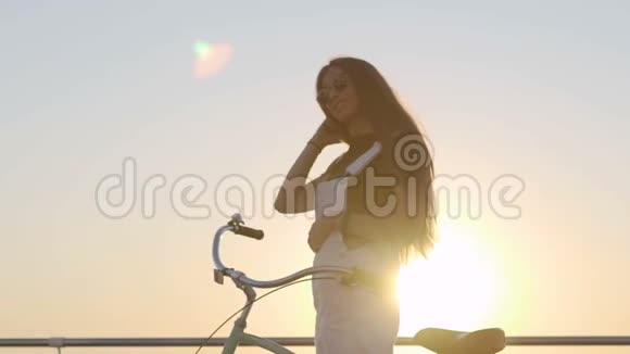 年轻漂亮的长发女人在海上玩得很开心有自行车的女性视频的预览图