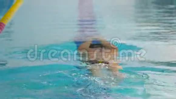 年轻运动员训练在蓝色游泳池里游泳视频的预览图