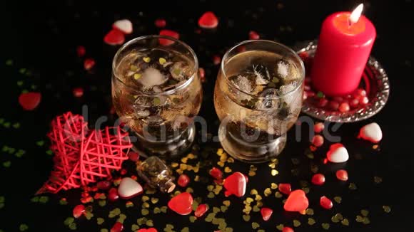 黑色背景下的浪漫静物蜡烛发出的火焰在酒杯中闪烁着酒精饮料视频的预览图