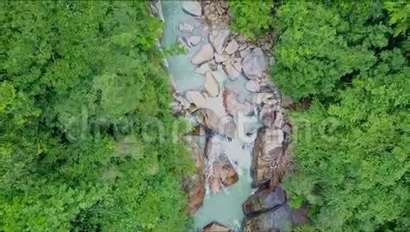 在茂密丛林之间的岩石上俯瞰河流视频的预览图